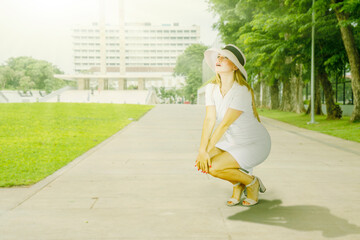 Woman in White Dress and Sun Hat Enjoying Sunny Day in Park