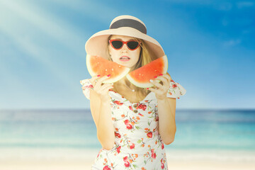 Summer portrait of happy young woman eating fresh tasty slice of watermelon wearing sunglasses and hat