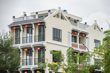 Beautiful building in antique style among green trees. The balconies of a modern hotel in Vietnam