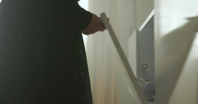 Woman Opens Cabinet At Home And Grab Tin Can Of Metal Cleaner. sliding reveal