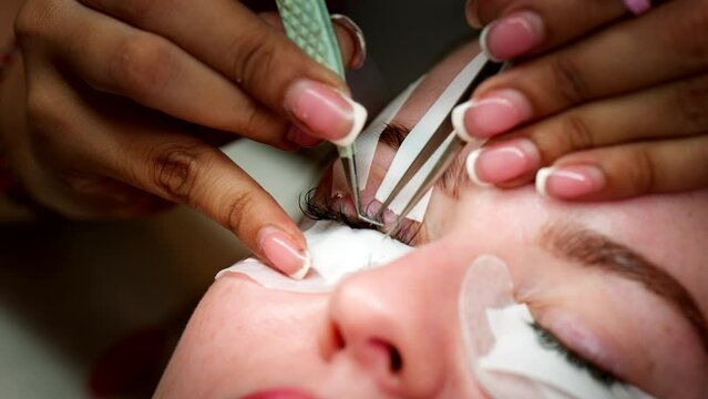 Attractive female, eyelash extension tweezers, facial care procedure
