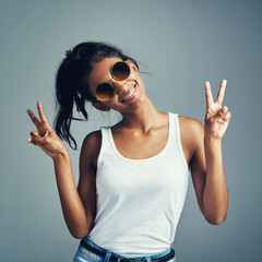 Studio, Indian woman and peace symbol with smile, confidence and trendy accessory as sunglasses....