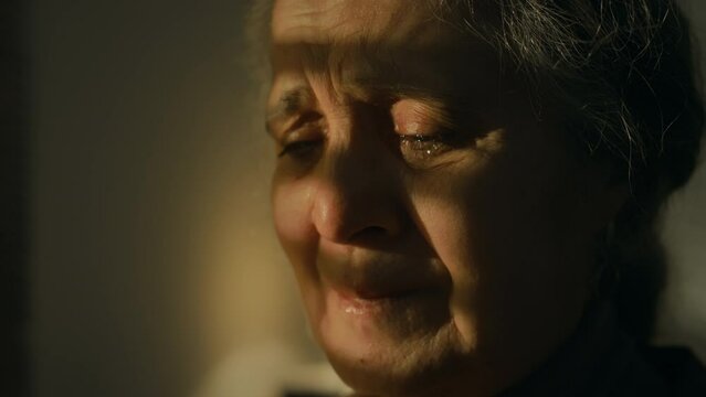 Closeup of crying Caucasian lady reading letter with bad news indoors, being full of tears feeling anguish and hopelessness