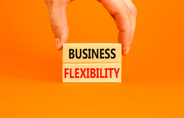 Business flexibility symbol. Concept words Business flexibility on beautiful wooden block. Beautiful orange paper background. Businessman hand. Business flexibility concept. Copy space.