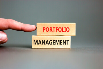 Portfolio management symbol. Concept words Portfolio management on beautiful wooden block. Beautiful grey paper background. Businessman hand. Business Portfolio management concept. Copy space.