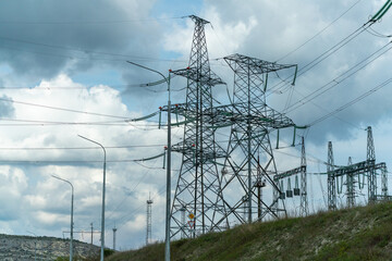High voltage towers with sky background. Power line support with wires for electricity transmission. High voltage grid tower with wire cable at distribution station. Energy industry, energy saving
