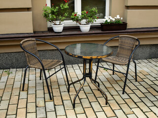 Table with chairs on the street near the entrance to the cafe
