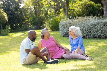 Fototapeta premium Outdoors, diverse senior friends laughing together in sunny park