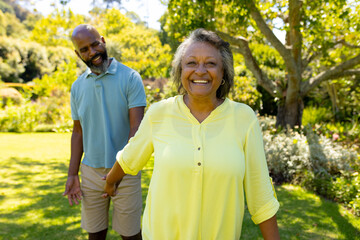 A diverse senior couple enjoying outdoors in sunny garden