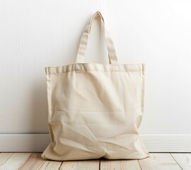 Plain beige canvas tote bag with handles, placed against a white wall on a wooden floor. - Powered by Adobe