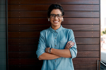 Obraz premium Business, woman and arms crossed on balcony for portrait, earphones and relax break for entrepreneur with confidence. Career, pride and listen or music or podcast, happy professional and employee