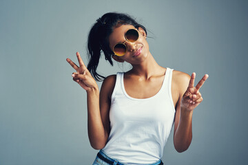 Studio, Indian woman and peace sign with smile, confidence and trendy accessory as sunglasses....