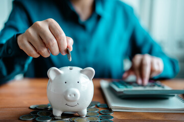 woman hand putting money coins into piggy bank for .planning saving money wealth to planning...