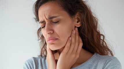 Fototapeta premium Woman with toothache holding her face in pain. Dental problem concept. Close-up portrait on white background.