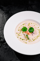 Gourmet creamy seafood soup in elegant white bowl