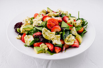 Fresh mixed salad with avocado and strawberries
