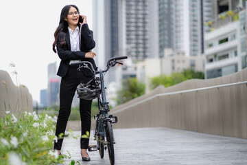 Smart businesswoman ride bicycle in downtown. Environmentalist commuting by cycling reduce carbon...