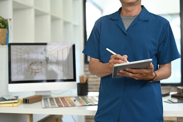 Cropped shot of senior male interior designer holding digital tablet in a modern creative studio