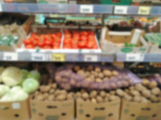 Blur background of vegetables, cucumbers, potatoes, cabbage, tomatoes on supermarket shelves. Retail industry. Local Farmers market. Grocery store. Greengrocers products. Food supplier. Inflation.