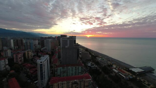 Time laps from orbi tower of a coastal cityscape at dusk with high-rise buildings and a cloudy sky in Georgia Batumi