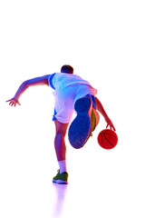Photo from behind of basketball player training, moves forward with ball in neon light against white studio background. Concept of professional sport, games, healthy lifestyle, tournament, action. Ad