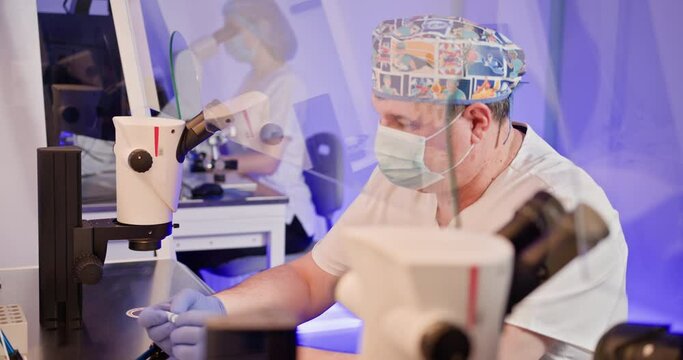 Embryologist in a laboratory setting performing artificial fertilization of a human egg using advanced equipment. Focused work in reproductive science. IVF process in action.