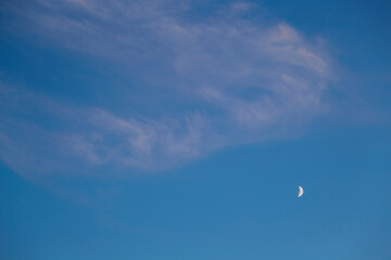 Fototapeta na wymiar Cloudy haze and moon in blue sky in the evening