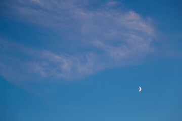 Cloudy haze and moon in blue sky in the evening