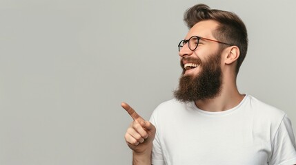 Cheerful Young Bearded Man Laughing and Pointing to the Side in White T-Shirt