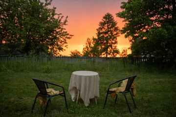 garden furniture table and chairs in the garden at sunset