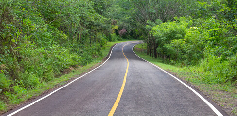 Curve way of asphalt road through the tropical forest in northern Thailand.