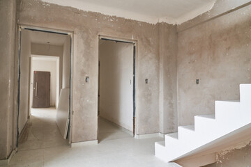 Doorway with staircase in incomplete corridor at construction site