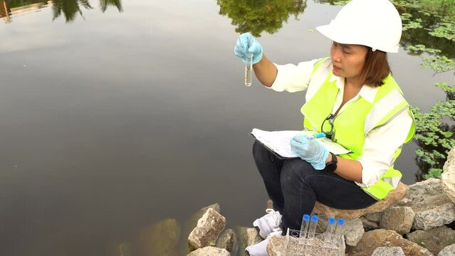 Environmental engineers and scientists inspecting water quality before treatment for potable use,checking water pollution,testing contaminants,collecting water samples for lab analysis to ensure safe