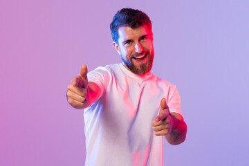 A man standing in a white shirt with a smile on his face, raising his thumb up in a positive...