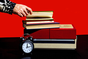 Hand of man opening book kept on vintage record player