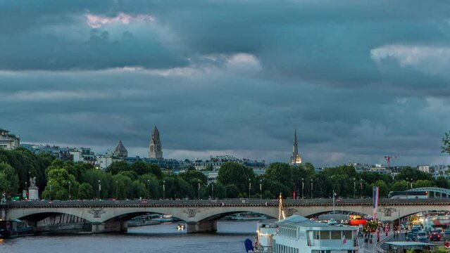 Bridge of Jena day to night transition timelapse, which connects the Champ de Mars gardens and the Trocadero. Boat station on Seine River near Eiffel tower. View from Bir-Hakeim bridge. Cloudy sky at