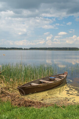 old wooden boat on the shore of the lake.