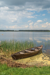 Obraz premium old wooden boat on the shore of the lake.