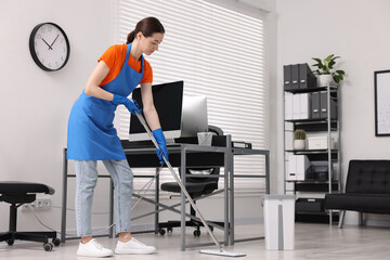 Cleaning service. Woman washing floor with mop in office