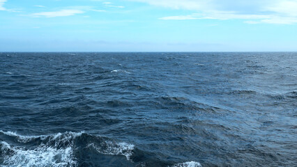 Beautiful view of horizon of blue sea with waves. Clip. Foam from waves in blue sea. In blue sea...