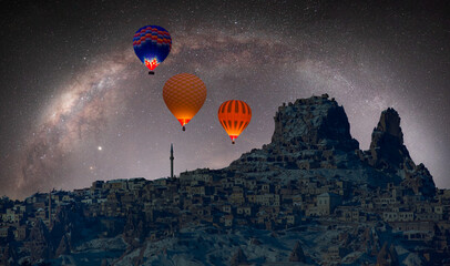 Hot air balloon flying over spectacular Cappadocia Milky Way galaxy in the background - Göreme,...