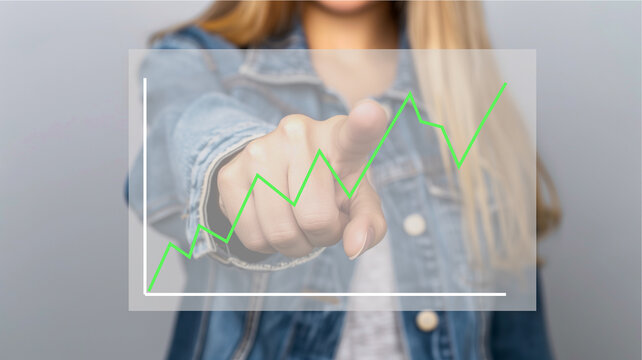 Mujer de negocios de pie se&ntilde;alando con un dedo de la mano una pantalla flotante un gr&aacute;fico econ&oacute;mico para negocio o finanzas.