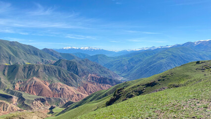 Fototapeta premium Majestic panorama of mountain peaks. Konorchek canyons in Kyrgyzstan. The mountains in the distance are covered with snow, and the sky is blue and clear