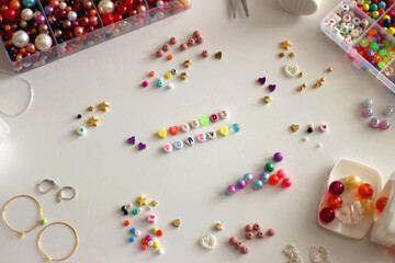 Friends forever written with colorful beads. Jewelry making supplies on the table. Making friendship bracelets concept. Selective focus.