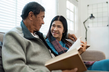 senior married couple enjoying quality time reading books together on the couch