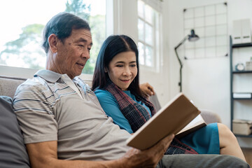 senior married couple enjoying quality time reading books together on the couch