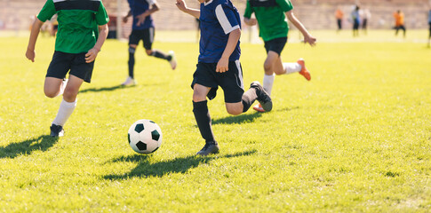 Happy kids compete in football game. Running soccer players. Competition between players running...