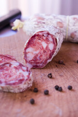 Traditional Argentinian salami with pepper on wooden background