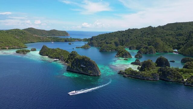 Raja Ampat, Indonesia: Aerial drone footage of a boat leaving the Piaynemo viewpoint famous for its limestone karst landscape in Raja Ampat archipelago in West Papua in Indonesia. 