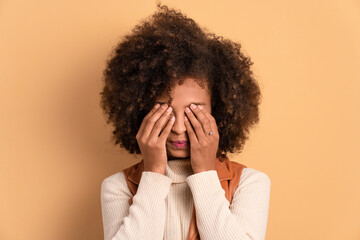 disappointed african american woman with sad face expression in all beige colors. frustration, unhappy, problem concept.